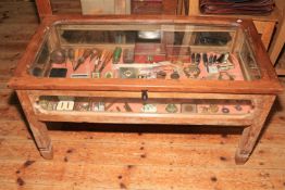 A bijouterie table containing collectables including military cap badges, WWI medals, pen nibs,