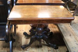 Victorian walnut fold top card table on carved pedestal to four scrolled legs,