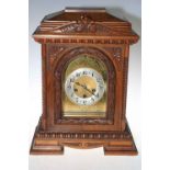 A large mahogany mantel clock on bracket feet, having arched dial, 48cm high.