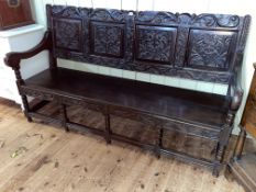 Jacobean style oak quadruple carved panel back open arm bench, 104cm by 182cm.