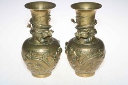 Pair of bronze vases decorated with raised serpents and dragons, 25cm high.