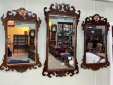 Three mahogany fretwork wall mirrors, including two with Phoenix crest.