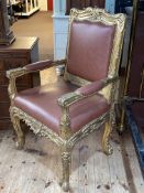 Gilt open armchair in studded tan leather.