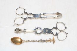 Two pairs of silver sugar nips and small ornate spoon.