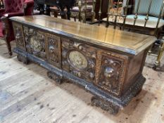 Large continental coffer carved with lion masks and fabric inset panels, 60cm by 168cm by 53cm.