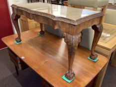 Rectangular shaped top walnut coffee table on ball and claw legs, 47cm by 92cm by 45cm.