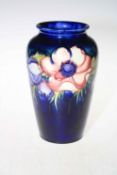 Moorcroft vase decorated with anemone design on a blue background, 22cm high.