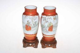 Pair of Oriental vases decorated with figures, birds and fauna on wood stands,
