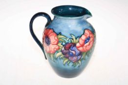 Moorcroft jug decorated with anemone design on a light blue background, 22cm high.