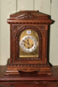 A large mahogany mantel clock on bracket feet, having arched dial, 48cm high.