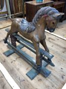 Painted wooden rocking horse on safety stand, 105cm by 124cm.