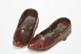 A pair of early 18th Century red leather children shoes with painted toes and sewn seams c1700-1720.