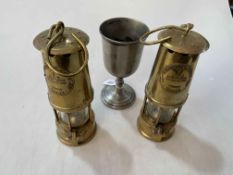 Two miners lamps and Britannia metal goblet (3).