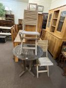 Weathered circular teak patio table and two chairs.
