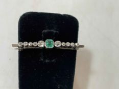 Emerald and ten stone diamond bar brooch, 4.5cm length.