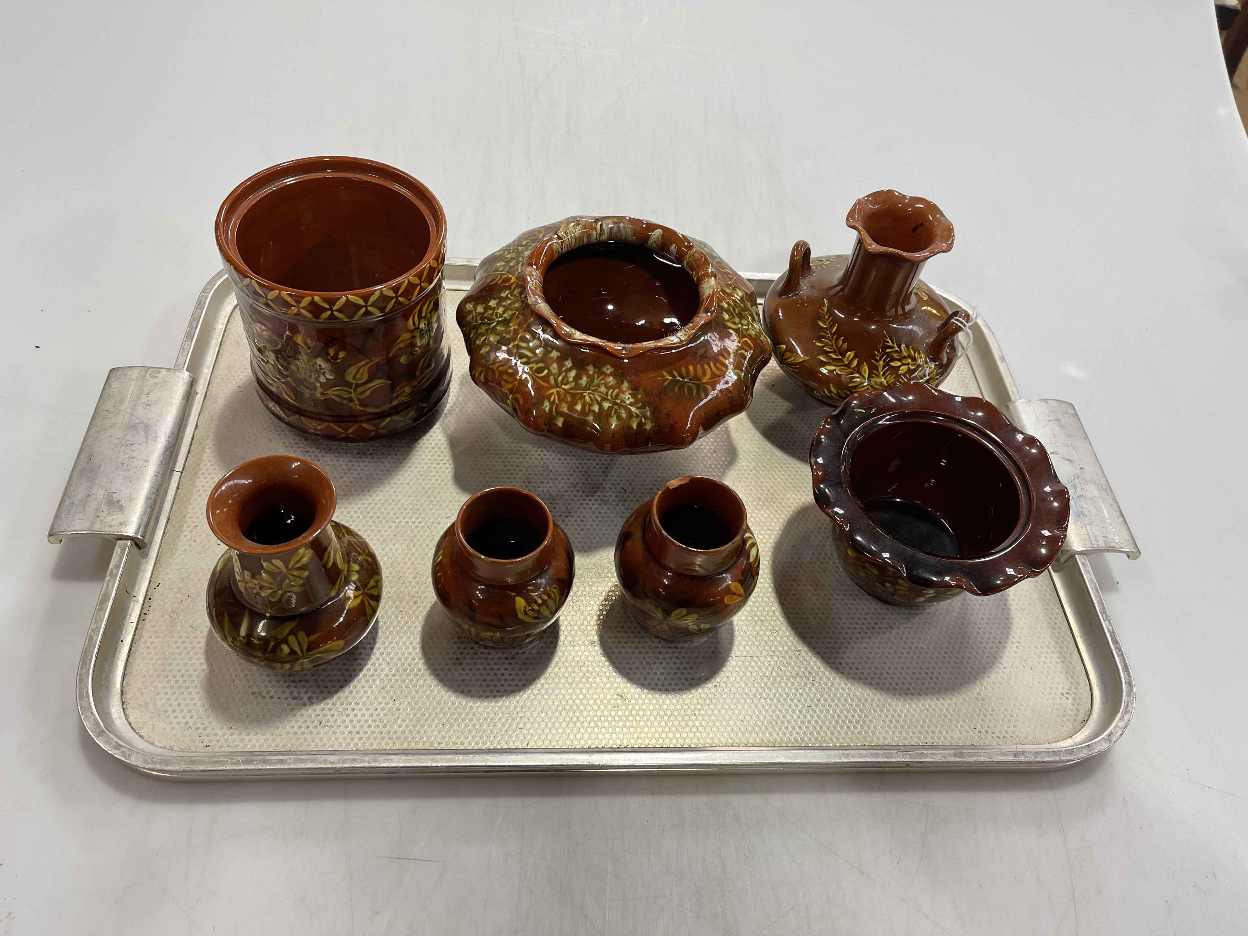 Linthorpe Pottery: seven pieces of floral decoration on brown ground.