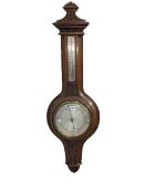 Carved mahogany aneroid barometer having silvered dial.