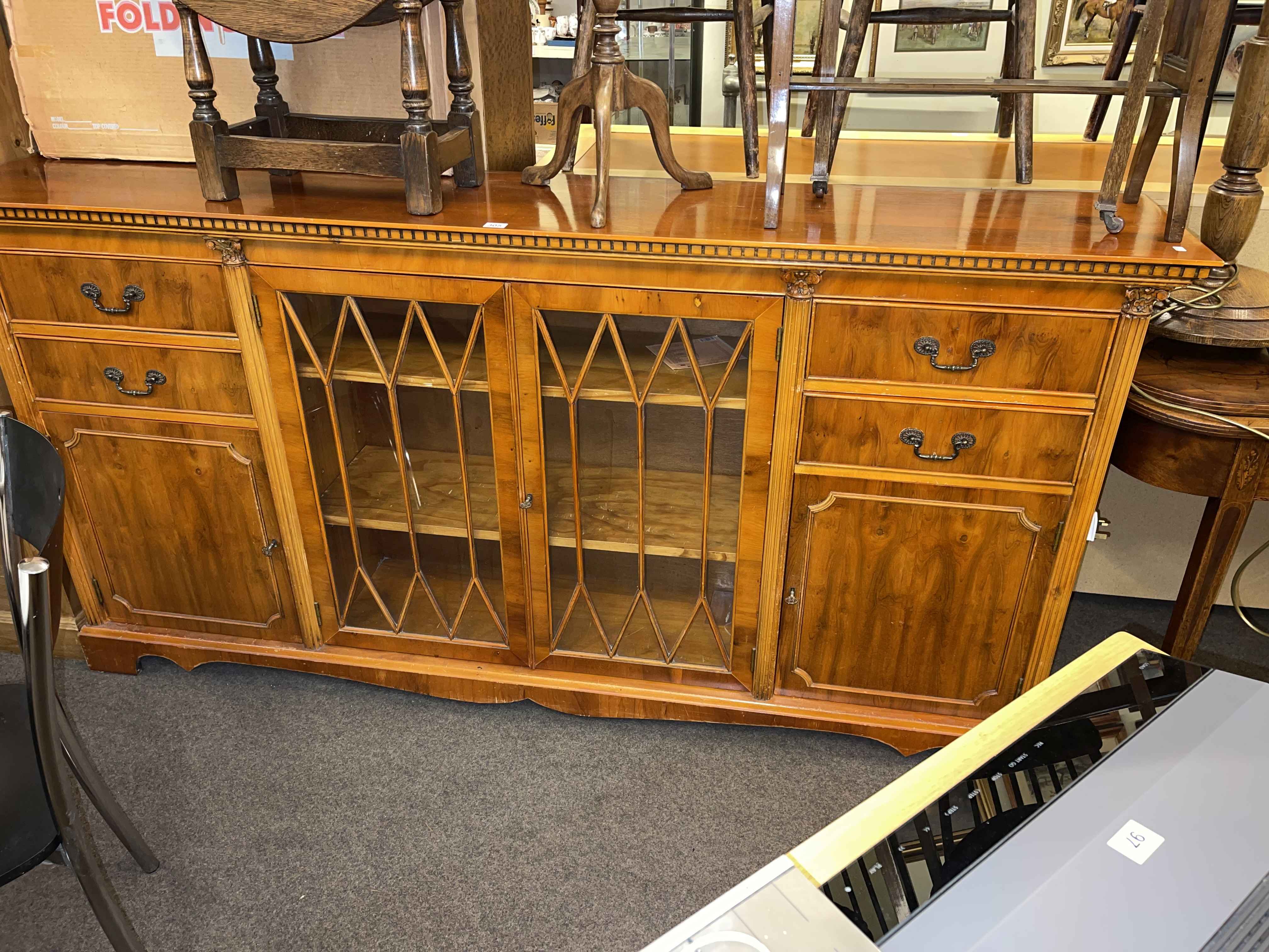 Yew cabinet bookcase having two central glazed panel doors flanked by four drawers and two cupboard