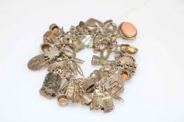 Silver charm bracelet with approximately forty charms.
