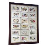Collection of eighteen WWI silk postcards framed as one, 67cm by 52cm.