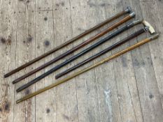 Four silver mounted walking sticks and another walking cane.