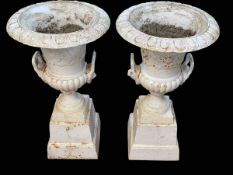 Pair cast Campana style garden urns on stepped plinth bases, 85cm by 46cm diameter.