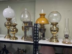 Collection of six oil lamps and one electric lamp, and a collection of oil lamp glass chimneys.