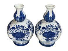 Pair of 19th Century Chinese blue and white vases decorated with floral design, 22.5cm.