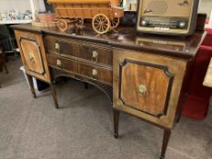 Early 20th Century mahogany inverted breakfront sideboard on eight square tapering legs,