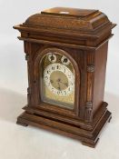 Oak cased bracket clock with brass and silvered dial, movement stamped Junghaus B07, 41cm high.