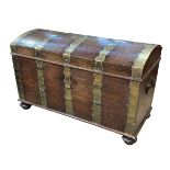 Large brass bound dome top trunk on bun feet, 76cm by 121cm by 63cm.