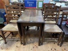 Oak gate leg dining table and set of four rush seated ladder back dining chairs.