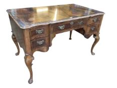 Mahogany crossbanded shaped front five drawer writing desk on cabriole legs, 76cm by 122cm by 73cm.