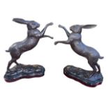 Pair of bronze boxing hares on marble plinths, 30cm high.