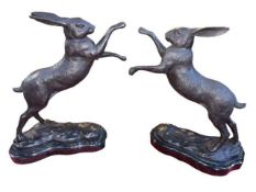 Pair of bronze boxing hares on marble plinths, 30cm high.