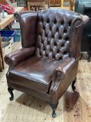 Thomas Lloyd brown deep buttoned back and studded leather wing armchair.