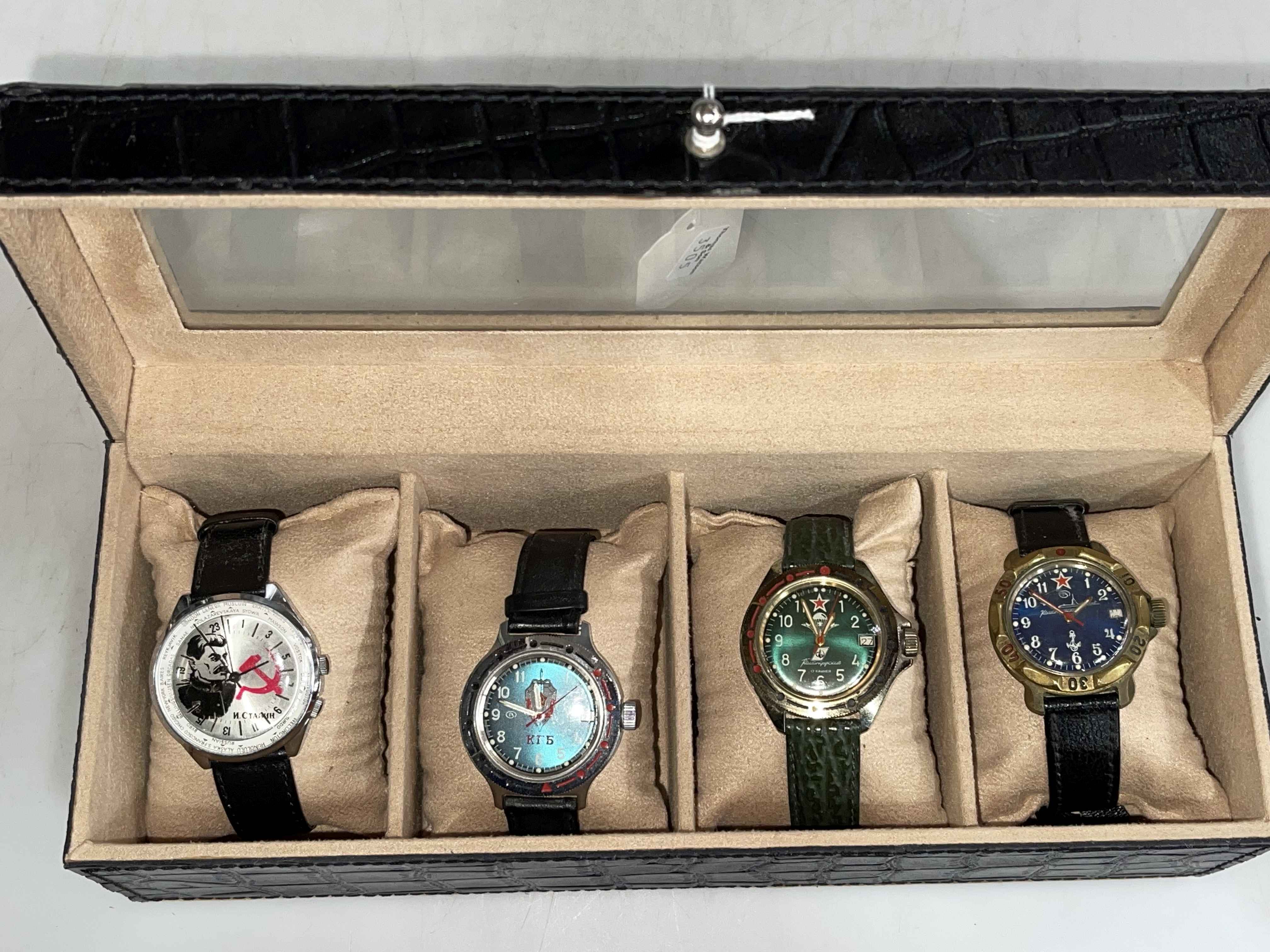Four Soviet era wristwatches, in display case.