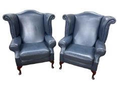 Pair blue leather wing back armchairs.