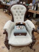 Victorian carved walnut framed armchair and two floral needlework footstools.