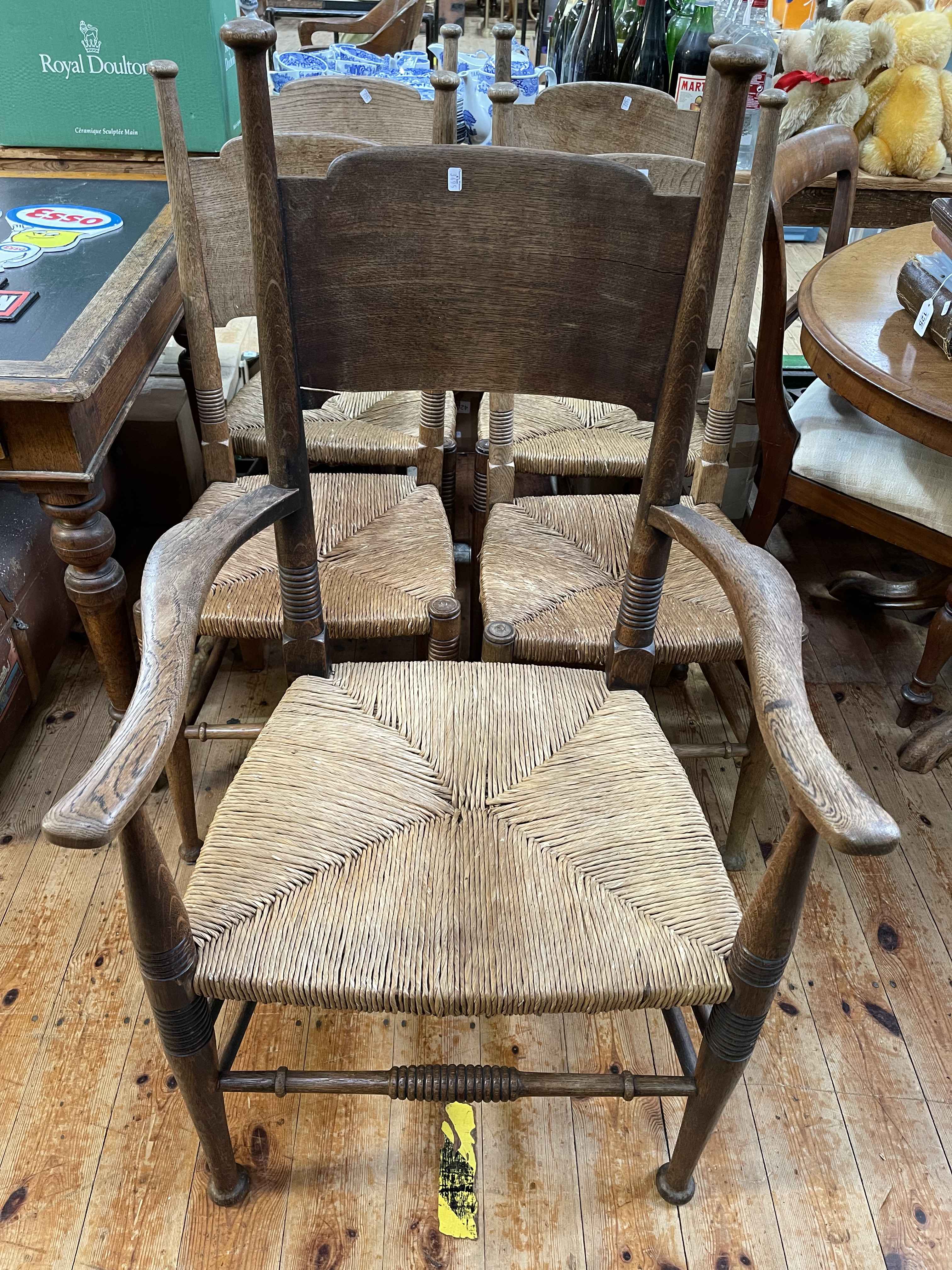 Set of five Country oak rush seated dining chairs, carver and four single.