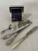 Silver charm bracelet, silver and mother of pearl butter knife, small silver frame,