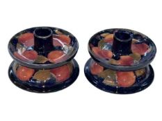 Pair Moorcroft Pomegranate dwarf candlesticks, 12.5cm diameter.