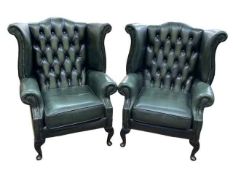 Pair bottle green deep buttoned back and studded leather wing armchairs.