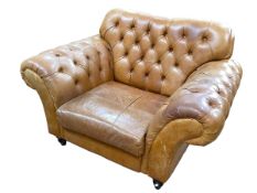 Large tan deep buttoned leather club armchair.