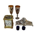 French gilt brass carriage clock, Arts & Crafts inkstand, pair goblets and two blue glass liners.