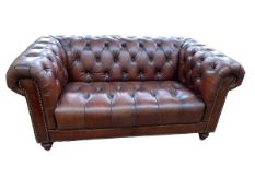 Brown buttoned leather and studded two seater Chesterfield settee.