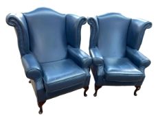 Pair blue leather wing back armchairs.