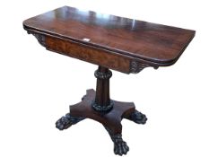 Regency mahogany fold top tea table on turned carved pedestal to quadriform paw feet base,