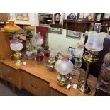 Collection of oil lamps including Cranberry glass, etched shades, brass columned,
