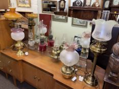 Collection of oil lamps including Cranberry glass, etched shades, brass columned,